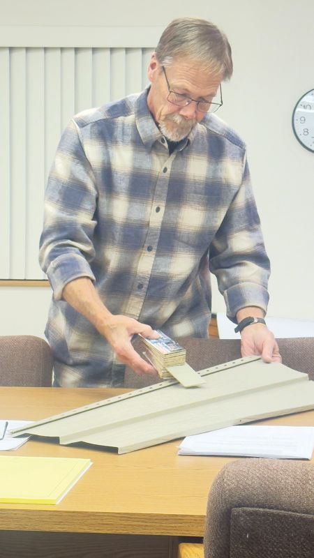 Eitzen Mayor Jeff Adamson looking at siding colors for the community center during the city’s October council meeting. Photo by Charlene Corson Selbee