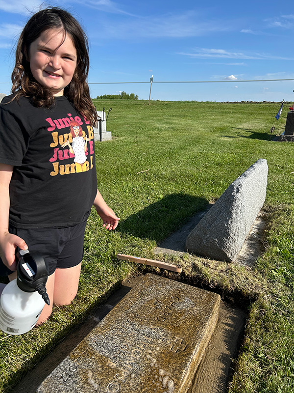 Gabby’s daughter Paisley Kinneberg cleans a headstone. Photo submitted