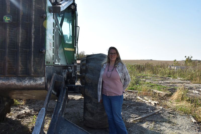Jenny Kleppe standing by the log skidder that she operates.