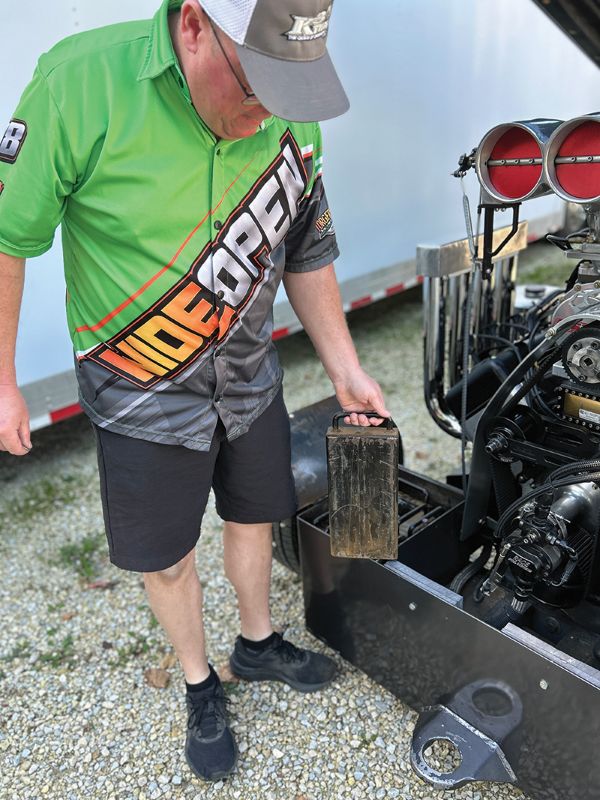 Roger holding one of the 50-pound weights which are placed above the axles of the truck. Photo by Wanda Hanson