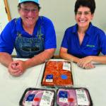 Greg and Deb Smith proudly share some of Wholestone’s pork products available locally at Hometown Foods. Photo by Wanda Hanson