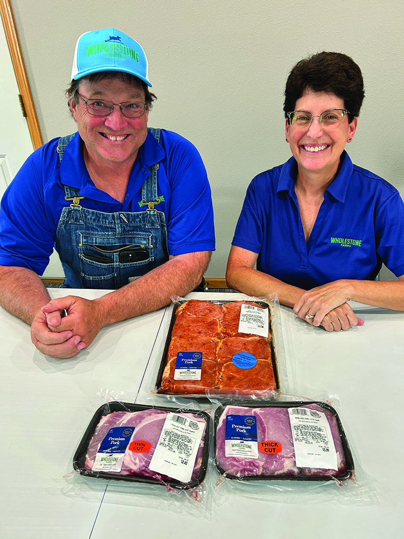 Greg and Deb Smith proudly share some of Wholestone’s pork products available locally at Hometown Foods. Photo by Wanda Hanson