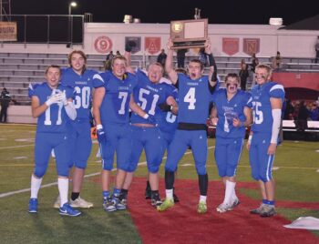 Mabel-Canton seniors (left to right) Mason Yoder, Michael Kime, Darian Hershberger, Milton Hutchinson, Isaac Underbakke, Kale Tollefsrud, and Nate Nordsving (plus an occluded Kenny Hutchinson) are all smiles after beating Spring Grove 16-0 in the 9-Man section 1 title game and earning M-C its first football state berth since 1981. Photo by Heather Kleiboer