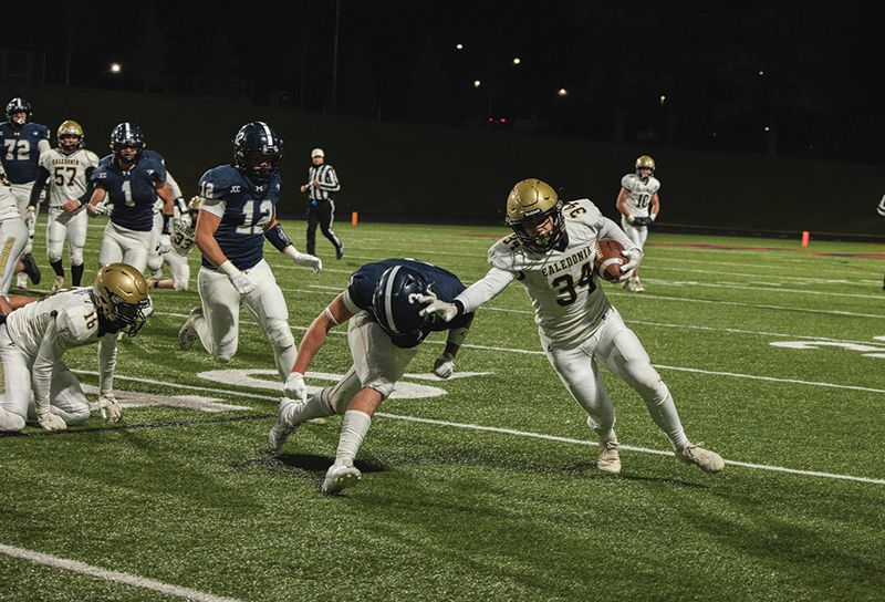 Caledonia’s Bo Knutson stiff-arms Jackson County Central’s Ben Gallagher on a run in the Warriors state quarterfinal loss. Knutson was busy with 42 rushing yards but 106 kick-off return yards. Photo by Isaac Blocker