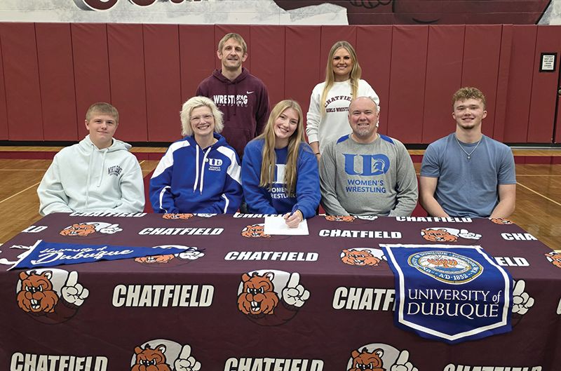 Chatfield’s Elle Eickhoff (middle front) recently signed a letter of intent to wrestle for the girl’s team at the University of Dubuque. She is pictured with her family (front row) brother Declan, mom Mindy, dad Chad, and brother Ethan. In the back row are her current wrestling coaches Matt Mauseth and Savannah Vold. Photo submitted
