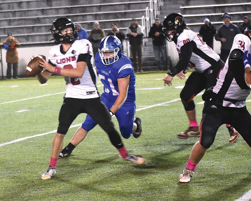 Mabel-Canton’s Milton Hutchinson closes in on Spring Grove quarterback Dylan Halverson. The senior Hutchinson was again a key cog defensively as the Cougars topped the Lions 16-0 to win the Section 1 9-Man title. Photo by Lee Epps