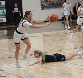 Fillmore Central’s Aubrey Daniels is on the floor having succeeded moments earlier in getting a jump-ball call with Caledonia’s Nicole Banse. The Warriors (then 3-1) topped the Falcons (then 3-0) by a 68-49 final as part of their two-win week, as they improved to 5-1 overall. Photo by Sara Kroshus
