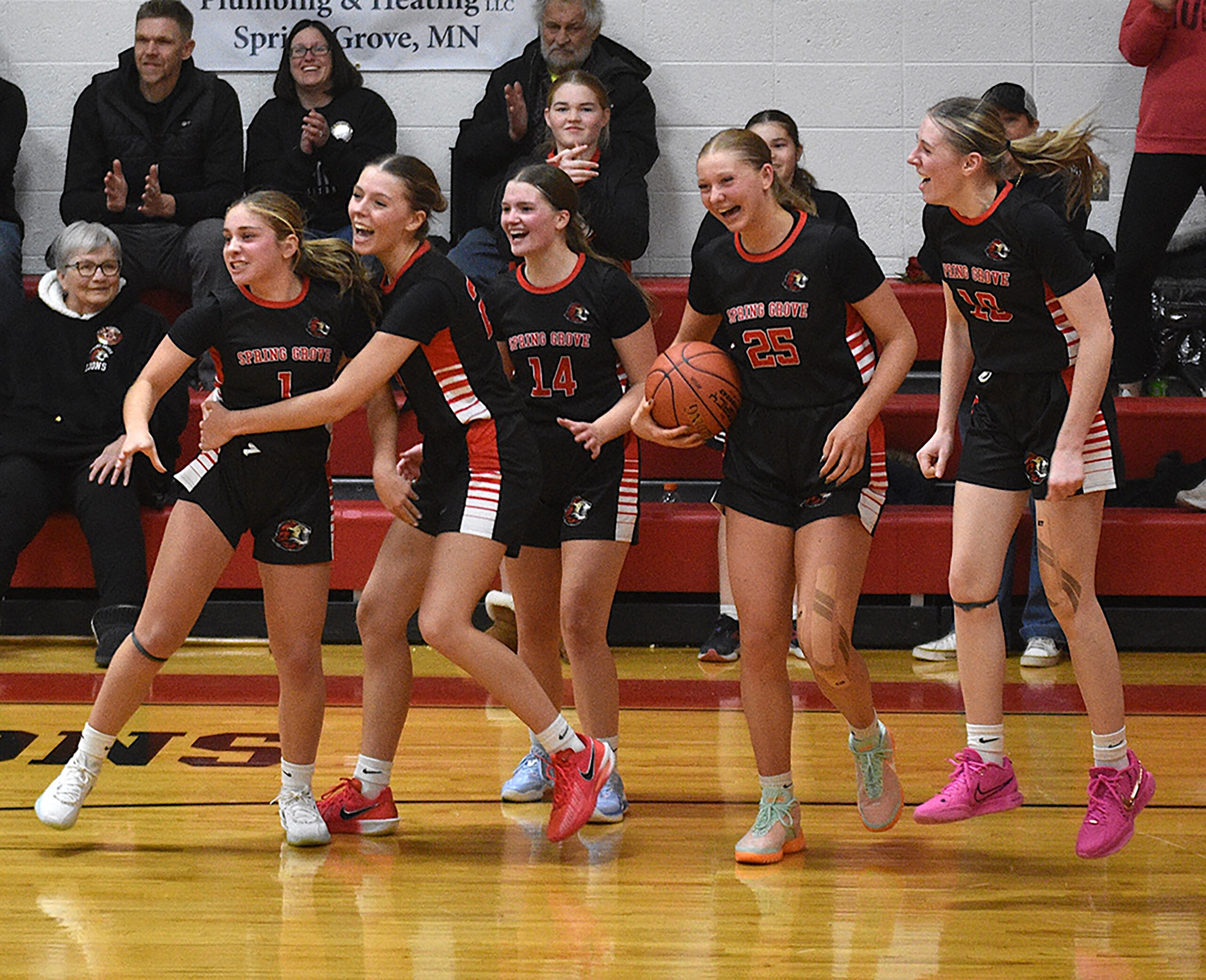 Spring Grove/Mabel-Canton girls (left to right) Siri Konkel, Kylie Hammel, Izabel Kaufmann, Kinley Soiney and Lauren Hammel celebrate an astonishing 61-60 comeback and last-second victory over previously undefeated Southland. The Lions (5-1, 7-2) took a half game lead over the Rebels (4-1, 5-1) and Lanesboro (4-1, 5-3) atop the SEC standings. Photo by Lee Epps