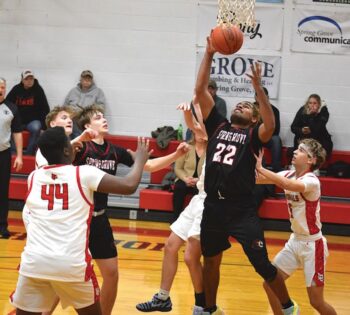 Spring Grove’s Devon Williams secures a rebound between LeRoy-Ostrander’s John Bradley (#44) and Mason Janssen (#5). Observing at left are Reid Hungerholt of L-O and Emery Bartell of SG. Williams had 18 points, 7 rebounds and 7 steals in the Lion SEC-opener win. Photo by Lee Epps