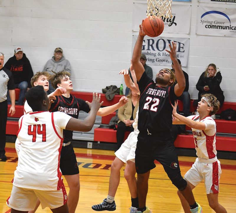 Spring Grove’s Devon Williams secures a rebound between LeRoy-Ostrander’s John Bradley (#44) and Mason Janssen (#5). Observing at left are Reid Hungerholt of L-O and Emery Bartell of SG. Williams had 18 points, 7 rebounds and 7 steals in the Lion SEC-opener win. Photo by Lee Epps