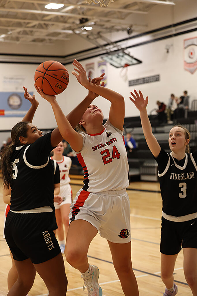 Spring Grove/Mabel-Canton’s Brinley Middendorf battles past Kingsland defenders Skylar Lentz and Reese Guy to release a shot in the Lions’ 51-28 SEC win. Photo by Christine Vreeman