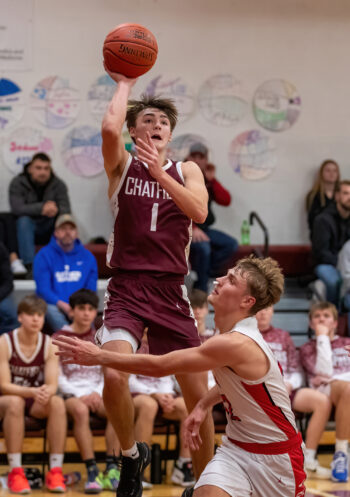 Chatfield’s Carson Harstad hangs in the air above Lewiston-Altura’s Gavin Bambenek in the teams’ TRC contest. The Gophers got outscore by eight in the second half to fall 73-67. Photo by Leif Erickson