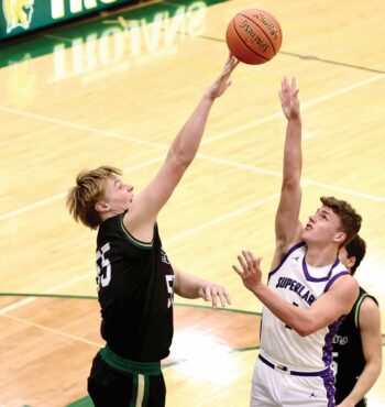 Rushford-Peterson center Brode Vickerman reaches for the block of the shot of Grand Meadow’s Carter Glynn in the Trojans’ 84-36 season-opening non-conference win. Photo by Craig Johnson