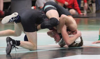 GMLOS’ Parker Armagost tries to pull FCLMC’s August Pfeffer over in a 133-pound match at the Wolves’ quadrangular that also included #4 in Class A Kenyon-Wanamingo and Wabasha-Kellogg. Armagost beat Pfeffer by fall, FCLMC beat GMLOS, while both teams beat W-K but lost to K-W. Photo by Paul Trende
