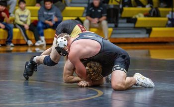 In maybe the dual’s most exciting match, Caledonia/Houston’s masked man Cooper Allen battles G-E-T/M-M’s #6 in D-II Aaron Dunigan. Allen fell by 15-13 decision, but he rebounded with a trio of wins at the Western Dubuque Duals. Photo by Emma Geiwitz