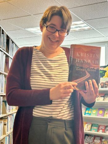 New Harmony Library Director Cara McCoy shares one of her favorite books to reccomend. Photo by Wanda Hanson