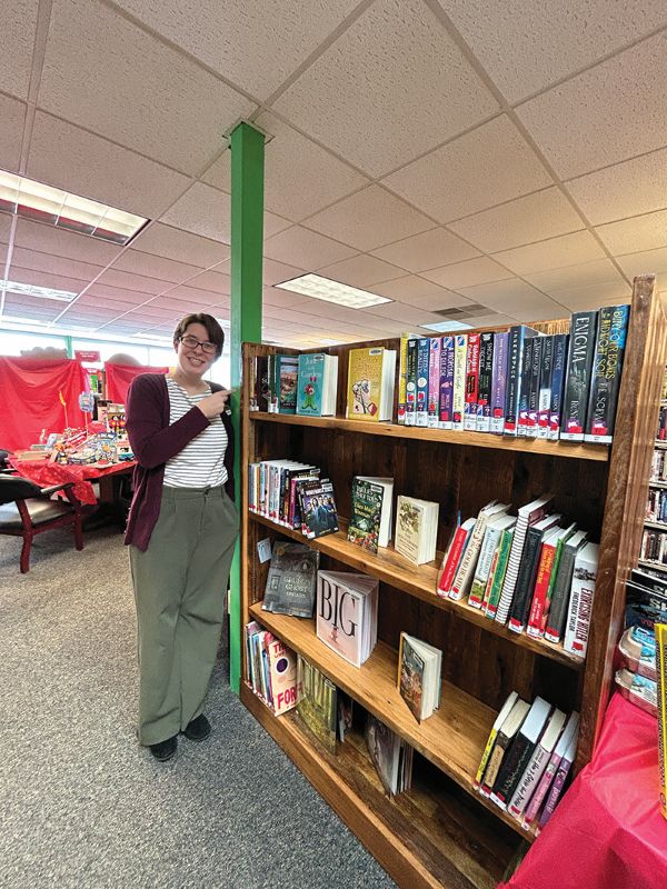 Cara points out the location of the newly arrived books at the middle of the library. Photo by Wanda Hanson