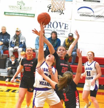 Grand Meadow’s Naomi Warmka tries to go reverse as Spring Grove/Mabel-Canton’s Kylie Hammell looks for the rejection. SG/MC (6-1, 10-3) topped the Larks 63-41, staying in the first-place race in the SEC with Southland (6-1, 10-2) and Lanesboro (5-1, 7-5). Photo by Lee Epps