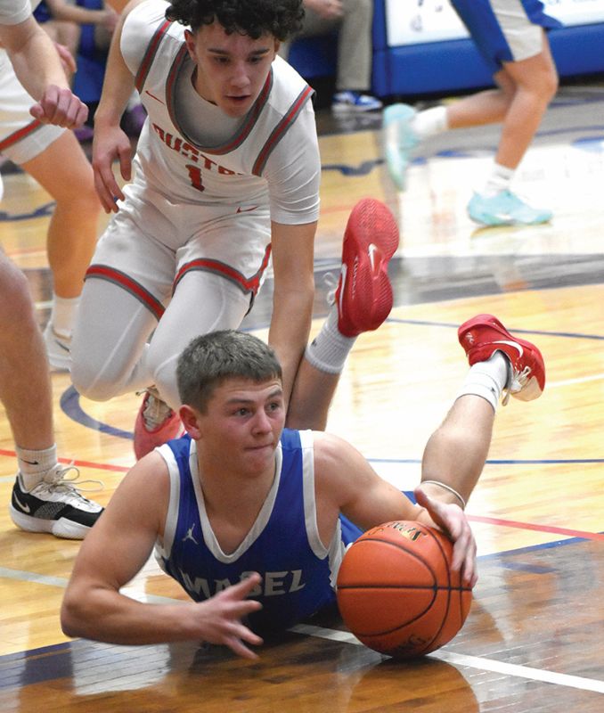 Mabel-Canton’s Kale Tollefsrud goes the floor for the ball as Houston’s Bennu Norton also looks to make a play in the Cougars’ 68-33 SEC win. Photo by Heather Kleiboer