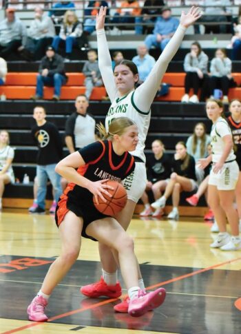 Rushford-Peterson’s Kaia Loney stands tall against the interior drive take of Lanesboro’s Emma Ruen in the Trojans’ 88-73 non-conference win. Photo by Ron Mayer