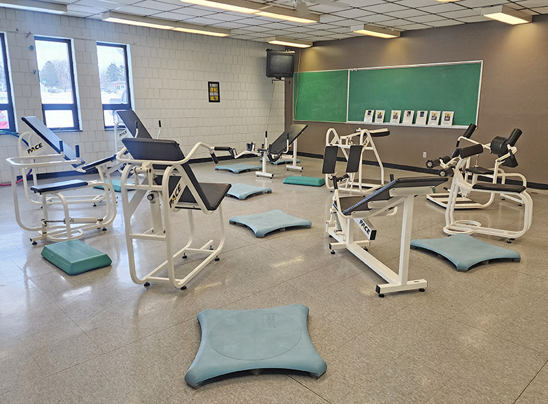 Hydraulic resistance exercise machines and balance platforms are part of the fitness center at Wykoff Commons, offering low-impact strength and mobility training in a repurposed classroom space. Photo by Zech Sindt