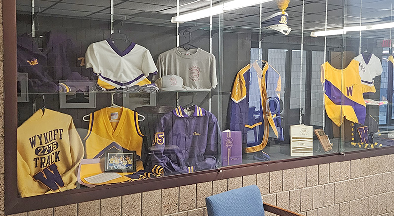 A hallway display case at Wykoff Commons features historic Wykoff school uniforms and memorabilia, offering a small museum-style look at the building’s past as a school. Photo by Zech Sindt