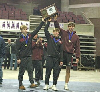 Chatfield’s Layne Root, Kaisen Johnson and Will Boelter grab the Section 1A wrestling title trophy after taking down Goodhue 33-31 in the finals. The Gophers three-peated as section champs and head back to state for a double encore. Photo by Paul Trende