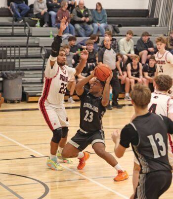 Devon Williams of Spring Grove is there defensively to try to curtail Kingsland’s KD Reiland in the Lions’ 78-60 SEC win. Photo by Christine Vreeman