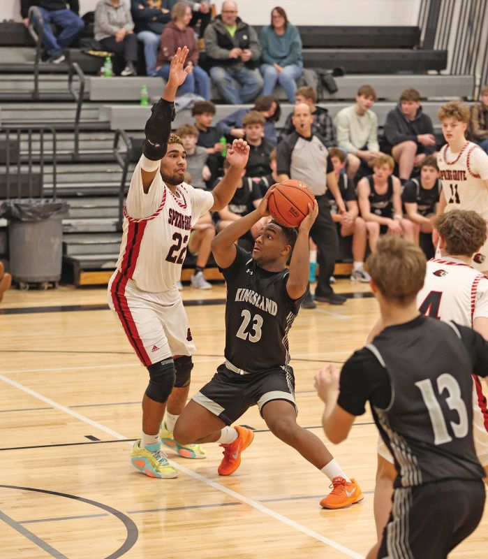 Devon Williams of Spring Grove is there defensively to try to curtail Kingsland’s KD Reiland in the Lions’ 78-60 SEC win. Photo by Christine Vreeman