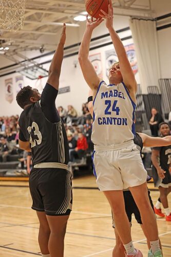 Mabel-Canton’s Darian Hershberger rises above Kingsland’s KD Reiland in the Cougars’ 76-57 SEC win, as M-C won its 12th game and fourth in a row. Photo by Charistine Vreeman