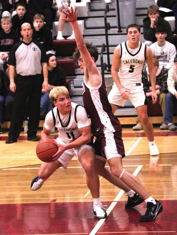 Caledonia’s diminutive Zeke Gengler looks for a shot-angle on Chatfield’s 6’3” Carson Harstad in the teams’ key TRC matchup. On the week, the Warriors (7-2, 10-6) beat the West second place Gophers 62-54 and East-leading Cotter/Hope Lutheran 78-64 to force a three-way tie atop the East with R-P (7-2, 14-3) and the Ramblers (7-2, 14-4). Photo by Paul Trende