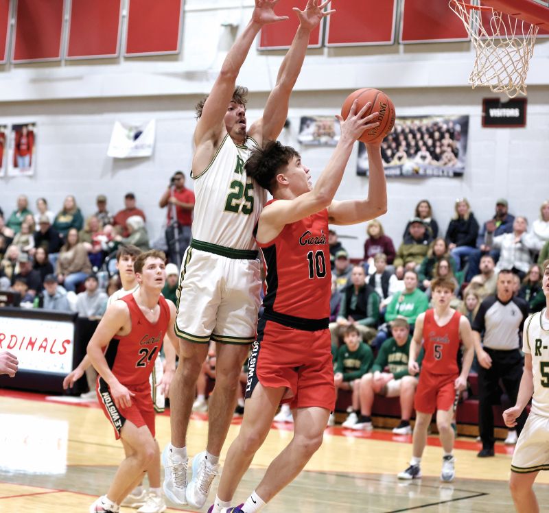 Rushford-Peterson’s Landon Dahl goes high to defend Lewiston-Altura’s Seth Lubinski in the teams’ key cross-divisional TRC game. R-P posted a 73-66 win, and the Trojans (7-2, 14-3), Cotter/HL (7-2, 14-4), and Caledonia (7-2, 10-6) are tied atop the TRC-East. Photo by Craig Johnson