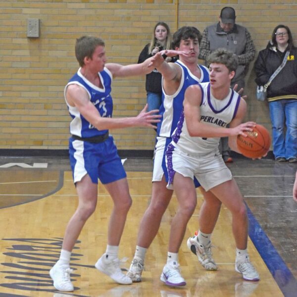 Grand Meadow’s Carter Glynn is hemmed in by Mabel-Canton defenders Nolan Garness and Cael Wangsness in the Cougars notable 79-47 SEC win. M-C improved to 10-5. Photo by Heather Kleiboer