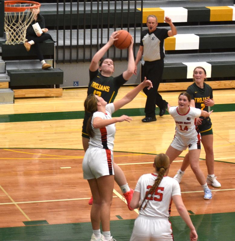 Rushford-Peterson’s Kaia Loney grabs the ball over Spring Grove/Mabel-Canton’s Brinley Middendorf in the teams’ non-conference battle. The Trojans came back from down 31-21 at the half to post a 67-55 win. Photo by Lee Epps