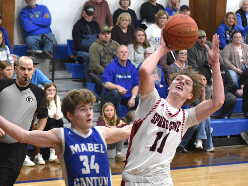 Spring Grove’s Kolton Nerstad plays through contact of Mabel-Canton’s Kale Eiken in the teams’ SEC matchup. The Lions posted a 76-73 win, sweeping the season series. Photo by Lee Epps