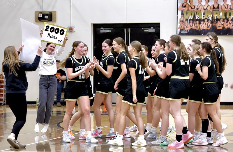 Caledonia managers hold up signs signifying senior Aubrie Klug (fourth player from left) and her accomplishment. Klug scored her 2,000th point in a Round of 16 playoff win over La Crescent/Hokah. Photo by Craig Johnson