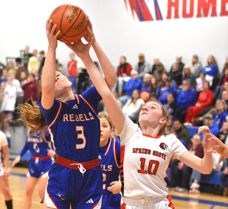 Spring Grove/Mabel-Canton’s Lauren Hammell tries to steal a rebound from Southland’s Brynna Nelson in the teams’ key SEC matchup. The Lions had a chance to tie the Rebels for the SEC title but fell 57-50. Southland (11-1, 21-4) takes the league over the SG/M-C (9-3, 15-8) and Lanesboro (9-3, 16-10). Photo by Lee Epps
