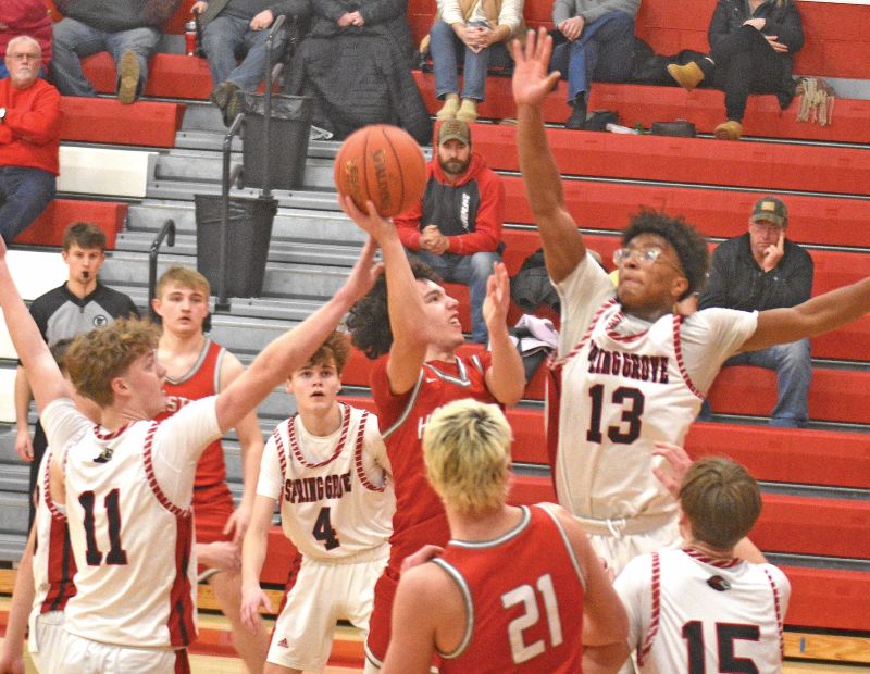 Spring Grove’s Ricardo Reynolds eyes a shot-block of Houston’s Bennu Norton while Lion Emery Bartell is behind the play in SG’s 75-41 SEC win. Photo by Lee Epps
