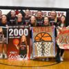 Spring Grove/Mabel-Canton’s Kinley Soiney (holding her own sign) poses with teammates after surpassing 2,000 career points in a Section 1A Round of 16 playoff win over Grand Meadow. Photo by Lee Epps