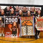 Spring Grove/Mabel-Canton’s Kinley Soiney (holding her own sign) poses with teammates after surpassing 2,000 career points in a Section 1A Round of 16 playoff win over Grand Meadow. Photo by Lee Epps