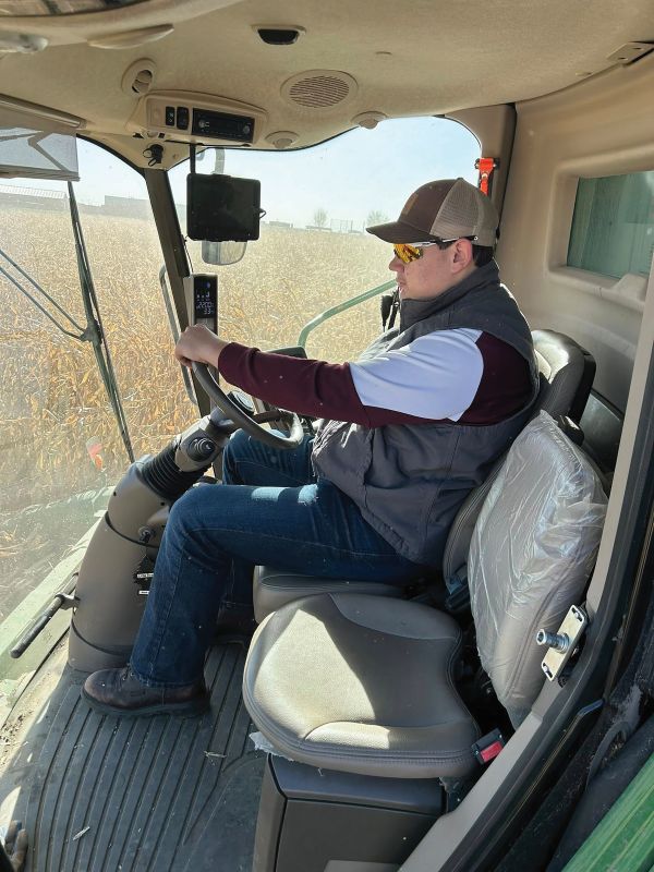 Plot harvest, senior Caden Voeltz operating the combine while harvesting the test plot. Supervised by Mitchel Berry.