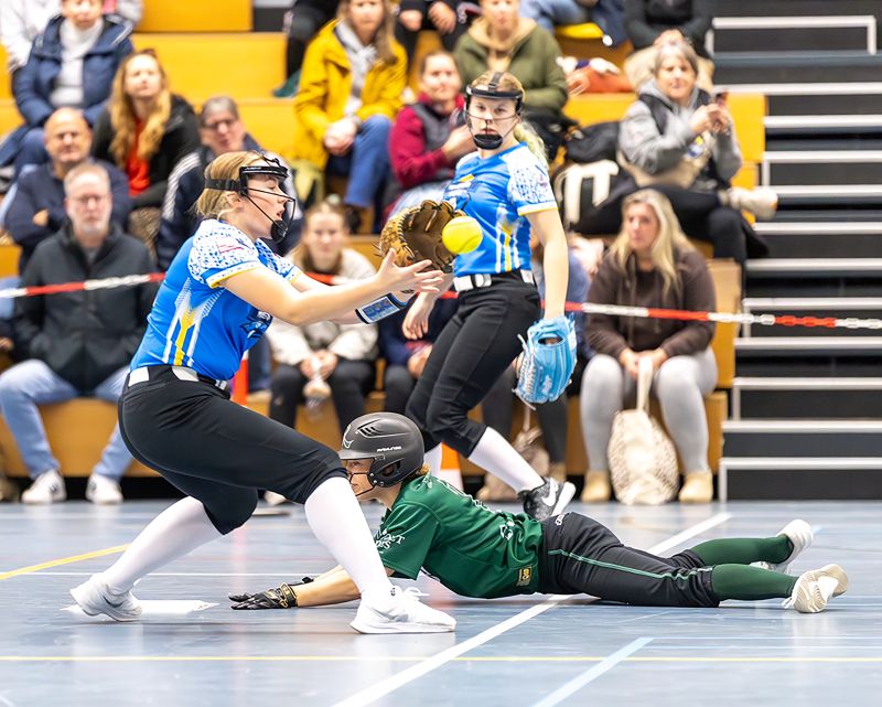 Kylie, standing center, in action at a play at home plate.