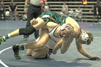 Chatfield’s Hunter Polikowsky does what he does and executes his best move, the fireman’s carry takedown on FCLMC’s Grant Daniels in a 145-pound finals match. Polikowsky won the match by fall but both athletes advanced to state. Photo by Paul Trende