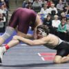 FCLMC senior Kane Larson uses his long arm to reach for the leg of Royalton/Upsala’s Jake Leners in a state title match at 189-pounds. Larson romped to the state title, winning his six post-season bouts by a combined 102-17 tally to become the Wolves’ first two-time state champion. Photo by Paul Trende