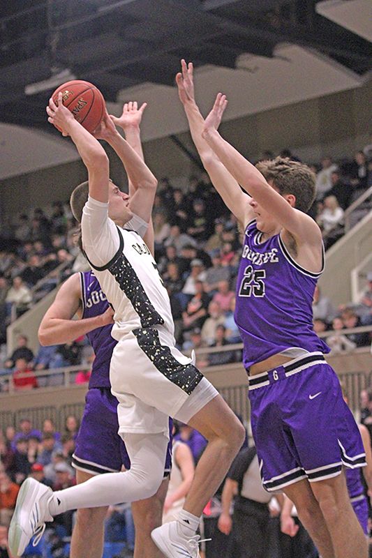 Caledonia’s Grant King takes the ball to the hole in a 1AA final versus Goodhue with Wildcat defender Cody Ryan also pictured. King scored 23 points including going over 1,000 for his career, but the Warriors fell 76-71. Photo by Paul Trende