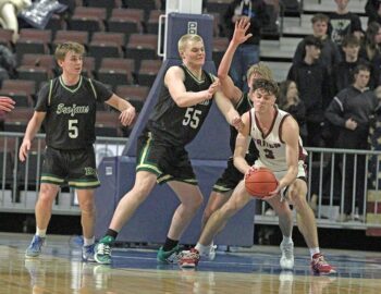 A trio of Rushford-Peterson defenders, Cayden Lea (left), Brode Vickerman (prominent), and Carson Johnson (obstructed) have eyes on Triton’s superstar Pierce Petersohn. The 6’5” senior, a Virginia Tech football signee, scored 39 points to lead the Cobras to an 84-76 win over the Trojans in a 1AA quarterfinal. Photo by Paul Trende