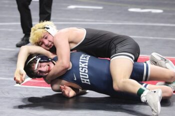 LARP’s Christian Zibrowski clamps down on Jackson County Central’s Mason Liepold in a state 127-pound fifth place match. Zibrowski went 4-2 for the state tourney including winning the above match to equal his state performance (fifth) from 2024. Photo by Paul Trende