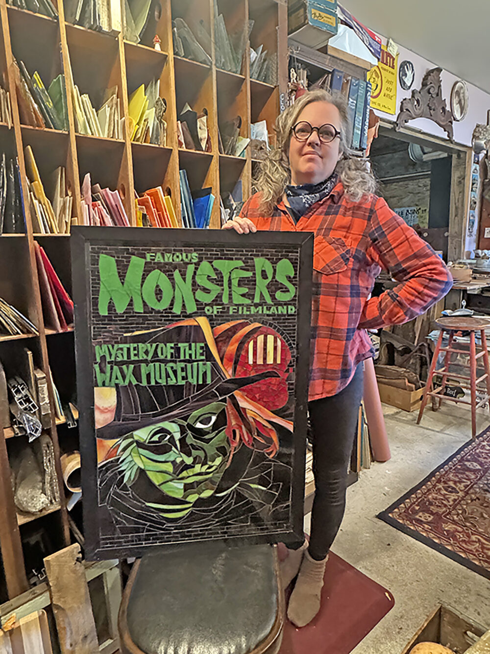 Rushford artist Nicole Burk with her favorite mosaic, Famous Monsters of Filmland: Mystery of the Wax Museum. Photo by Charlene Corson Selbee