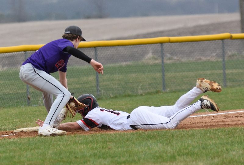 Spring Grove’s Gabe Klug slides safely into third base ahead of the tag by GMLOK’s Noah Tangen in the teams’ SEC match-up. The Bulldogs won in walk-off fashion by 7-6 final, as Tate Rasmussen authored the game-winning hit. Photo by Lee Epps