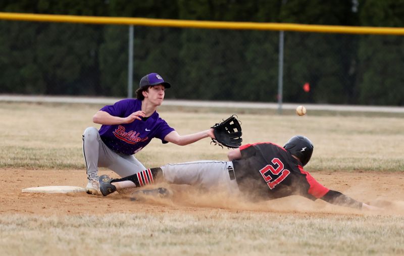 Kenyon-Wanamingo’s Caleb Edwards slides in safely at second ahead of the throw to GMLOK’s Jayden Smith in the team’s non-conference baseball clash. A 9-9 game after six innings turned into an 18-9 Knight win. Photo by Christine Vreeman